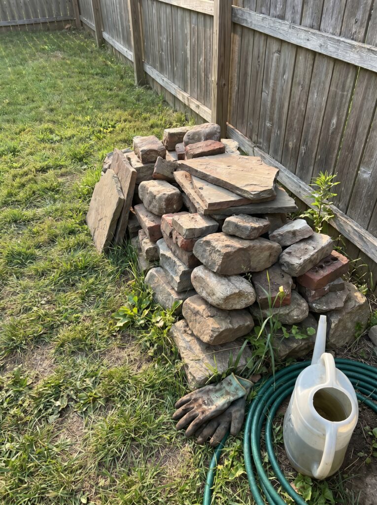 A pile of salvaged landscaping stones and old bricks ready for a DIY garden project.