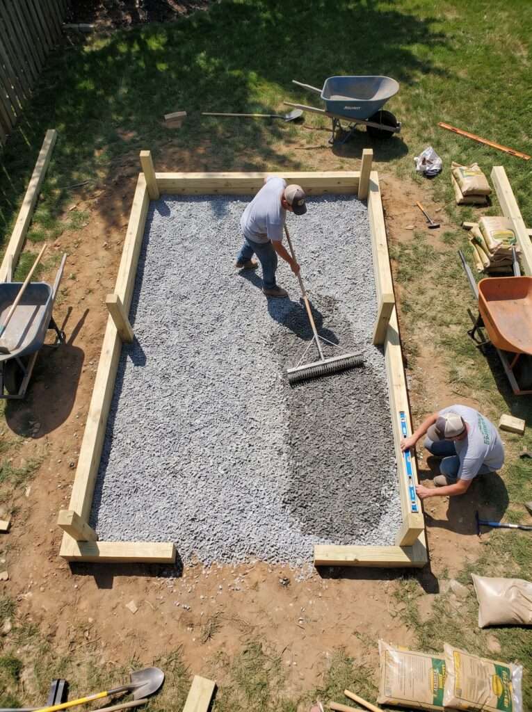 Spreading gravel base before building wooden enclosure frame