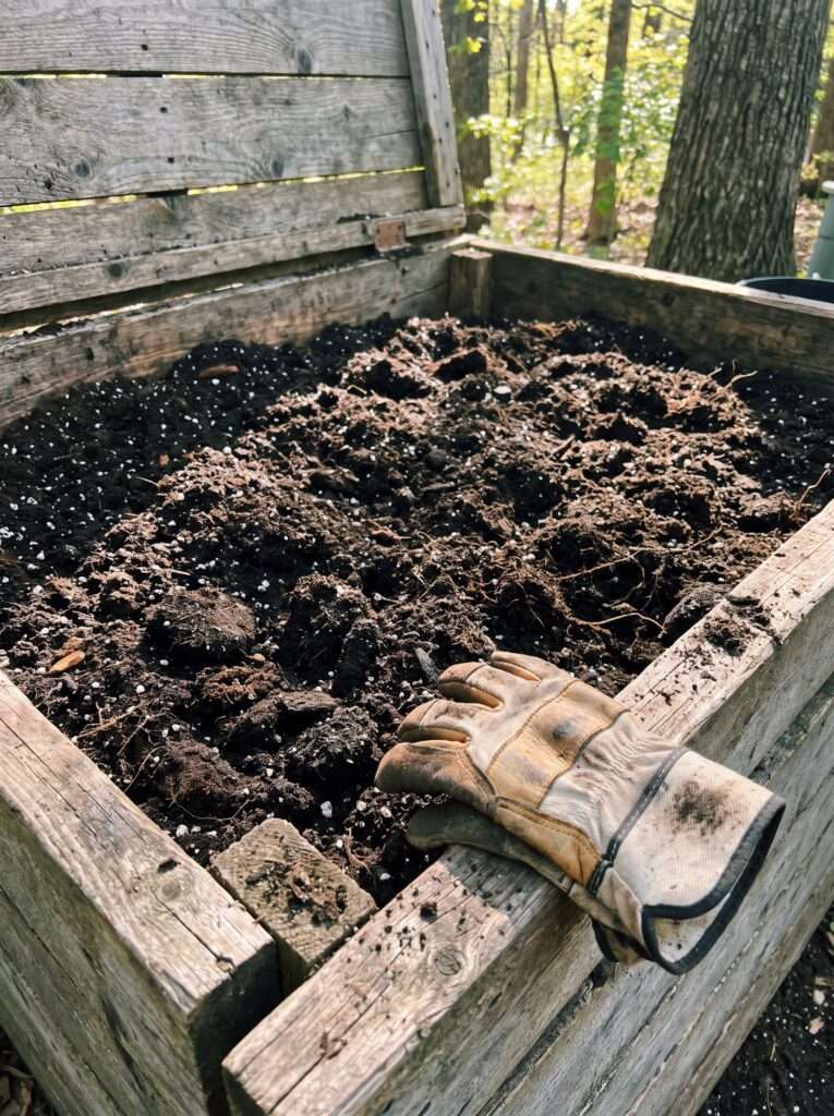 Hidden soil storage bin built into a wooden potting bench base