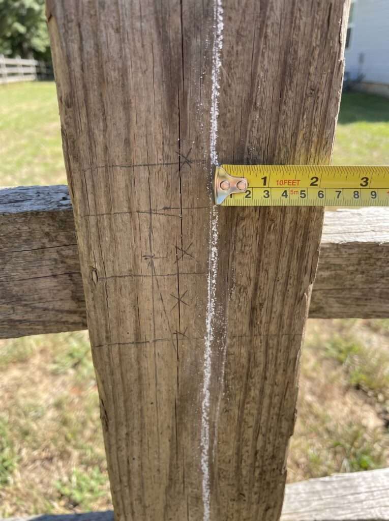 measuring and marking layout for a lean-to firewood shed against a fence 