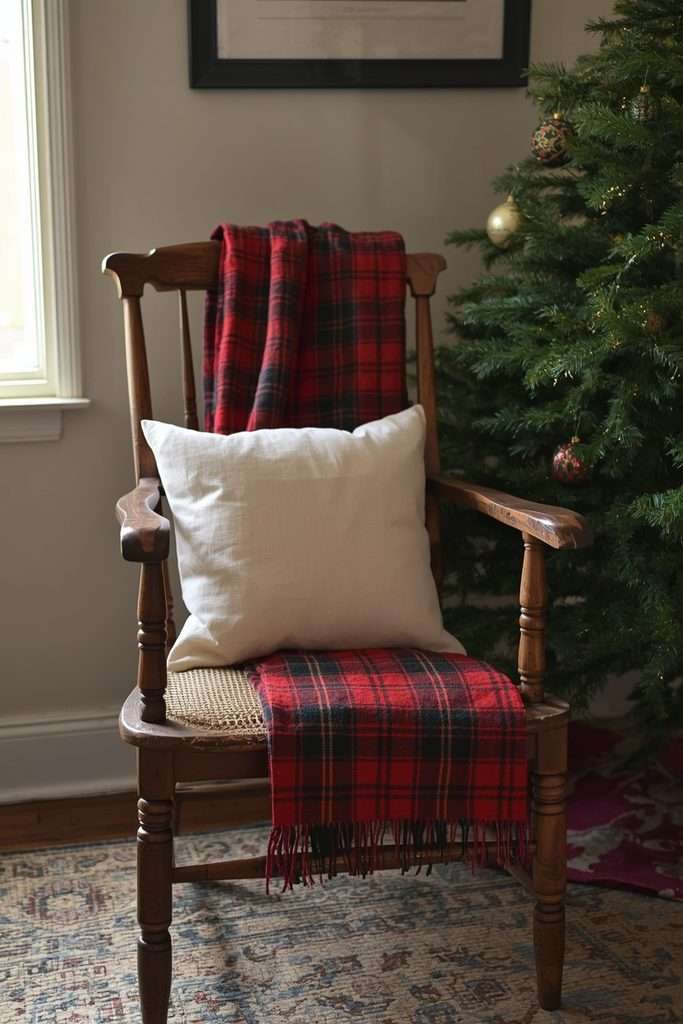 Red and green plaid blanket draped over a cozy Christmas reading chair.